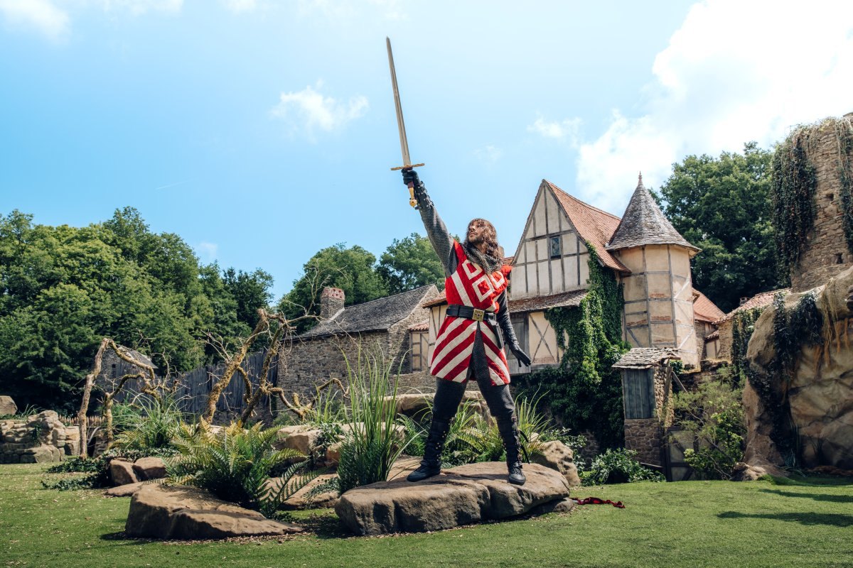 Tristan retire Excalibur de son rocher dans le spectacle L’Épée du Roi Arthur au Puy du Fou